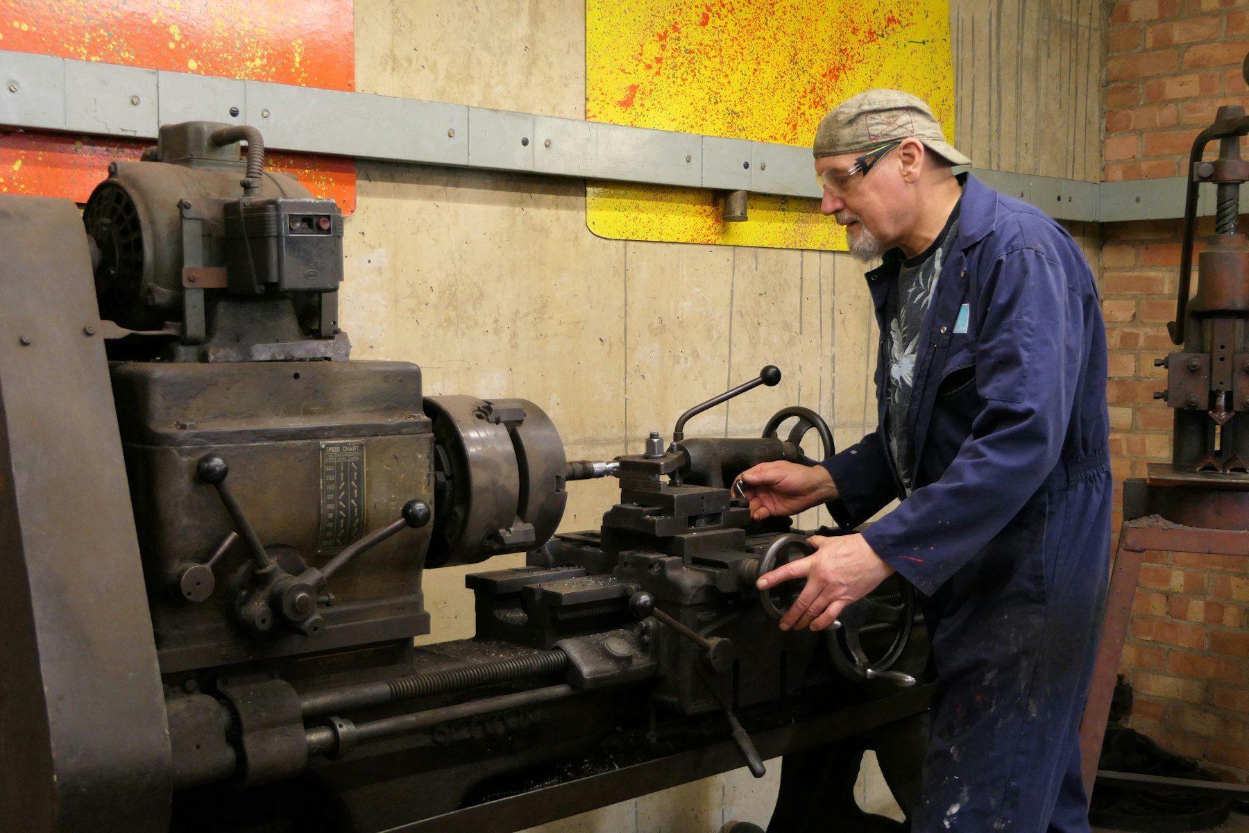 Mitarbeiter an einer Werkzeugmaschine in der Fertigungshalle